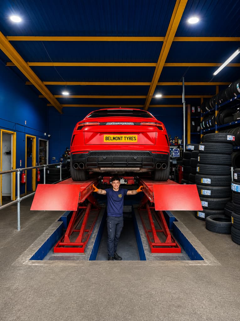 Inside the Belmont Tyres workshop in Liverpool, a car raised on the alignment rig